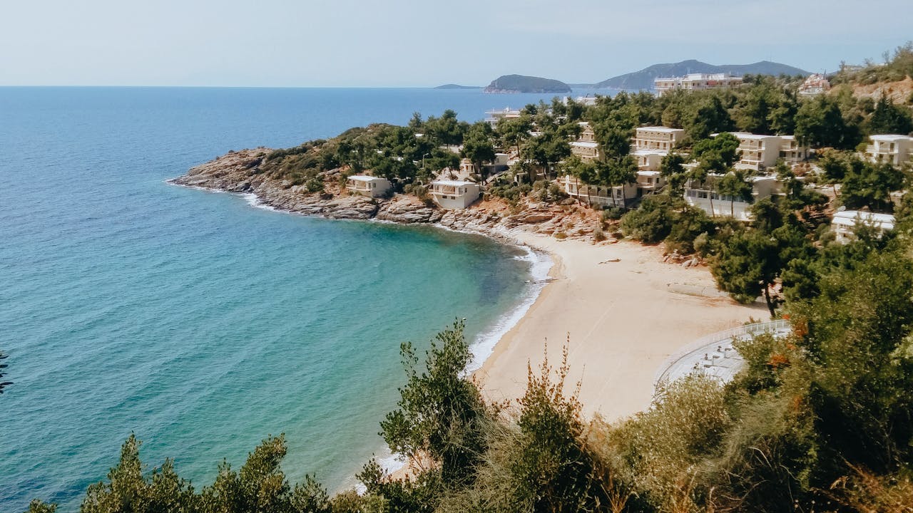 Mastering the First Impression: Your intriguing post title goes here A scenic coastal village with villas overlooking a pristine sandy beach and turquoise sea.
